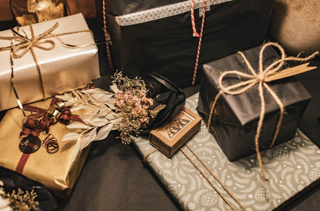 Gifts wrapped in shiny black and gold paper. 